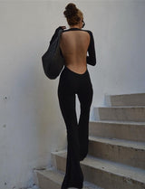 Woman posed standing from the back n in the black sexy backless jumpsuit